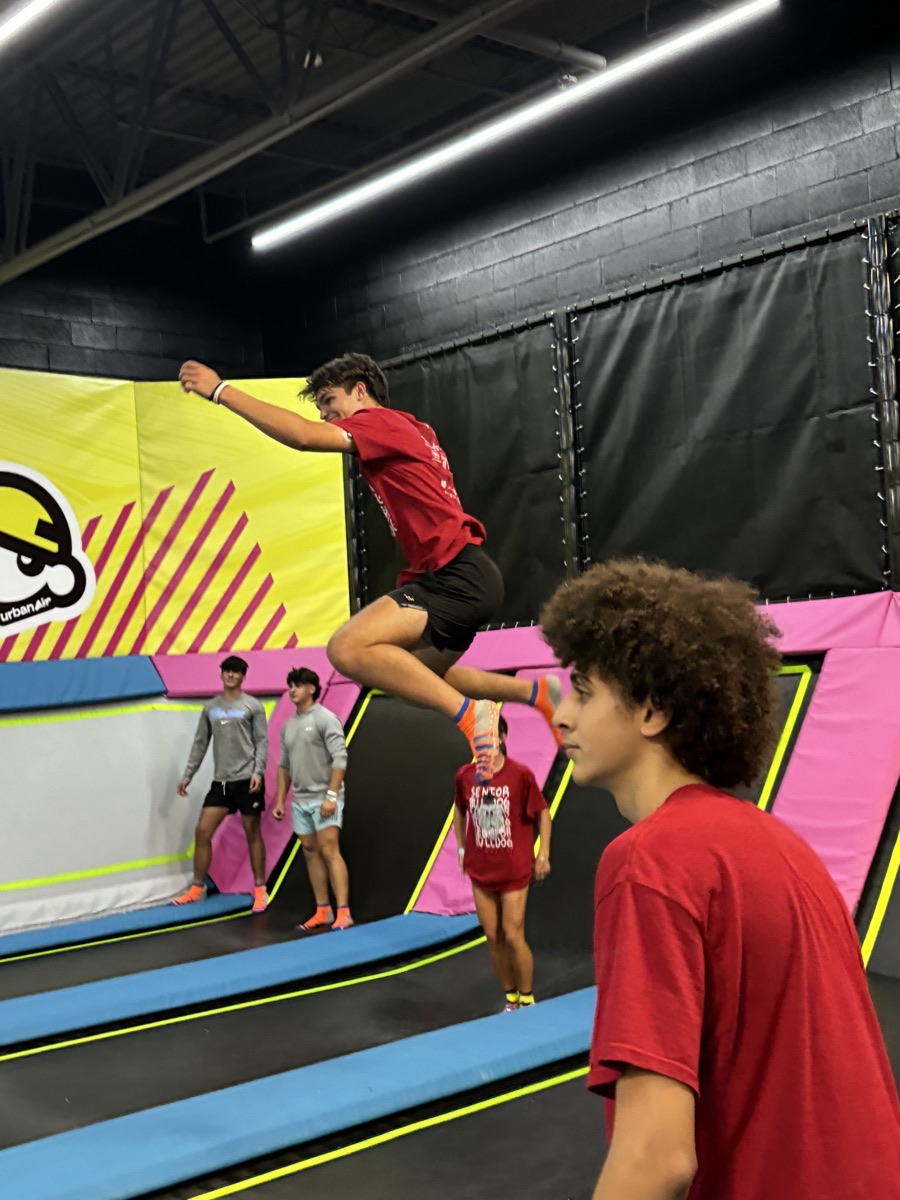 A graduate mid-air on the trampolines